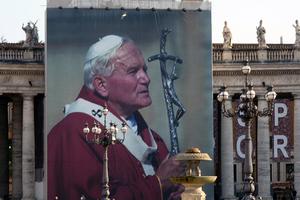 A giant image of Pope St. John Paul II hangs from the colonnade in St. Peter's Square.