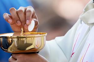 A priest distributes Holy Communion on Divine Mercy Sunday in St. Peter's Square, April 8, 2018.
