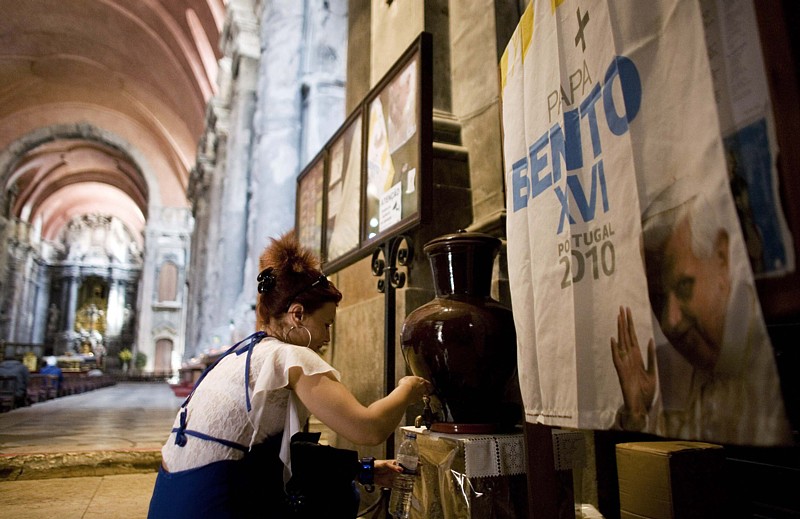 A woman prays in front of a statue of Our Lady of Fatima May 5 in Sao Domingos church in Lisbon, Portugal. Pope Benedict's May 11-14 trip to Portugal will focus on spiritual, political and economic questions seen as crucial for the country and the rest of modern Europe.