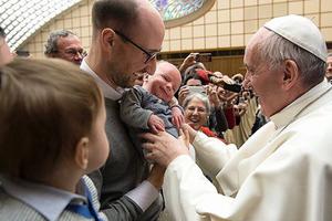 Pope Francis greets a family at the Vatican.