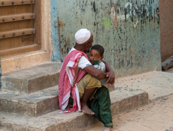 A little boy cries in the arms of his father, Shibam, Yemen, 2007.