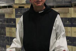 Spencer Brewery director Father Isaac stands in front of cases of Spencer Trappist Ale, the first certified Trappist beer made outside of Europe. 
