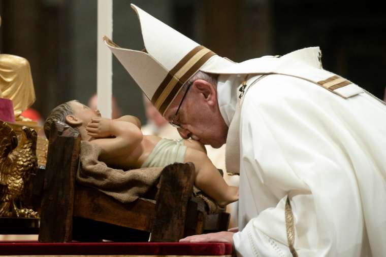 Pope Francis kisses an image of the Christ Child at Christmas Mass in St. Peter's Basilica Dec. 24, 2018.