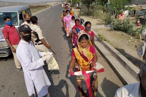 A long line of residents line up for food and relief distribution offered by St Xavier's College of Management and Technology, Patna.