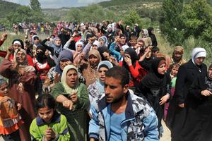 Syrian refugees gather on the Syria/Turkey border. 