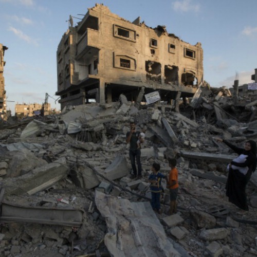 A Palestinian family walks through the rubble of a destroyed area of housing on Aug. 16 in Gaza City, Gaza.