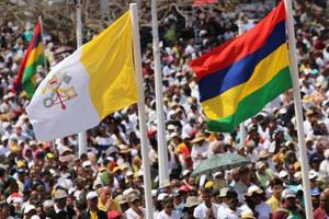 People wave flags during Mass with Pope Francis in Port Louis, Mauritius, Sept. 9.