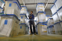 WATCHFUL EYE. An employee of the Independent High Electoral Commission checks boxes containing parliamentary ballots in Basra, Iraq, March 8. Officials said more than 55% of Iraqis voted in the country's parliamentary election despite attempts by Sunni Islamist insurgents to disrupt the vote with attacks that killed at least 38 people. 