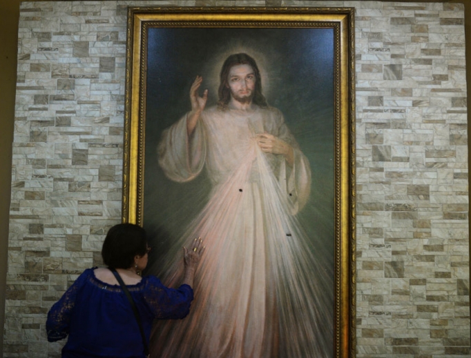 Faithful pray July 20 before a Divine Mercy image that was struck by bullets during an attack by government forces at the Divina Misericordia Church in Managua. July 14 students of the Autonomous University of Nicaragua took refuge in the church during protests and were attacked by police and armed civilians; the confrontation left two dead and several wounded.
