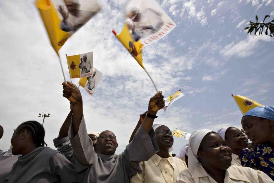 Cameroonians wave good-bye with papal flags as Pope Benedict XVI's plane departs today.
