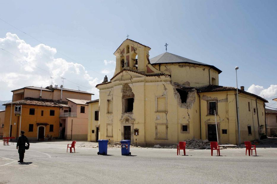 An Italian soldier stands in front of a damaged church in the Italian village of Paganica after today's earthquake.