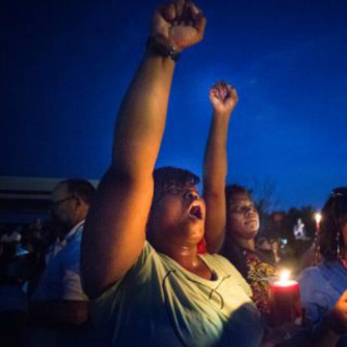 Protestors hold candles as they shouted, ‘Hands up’ during a protest in Ferguson, Mo.