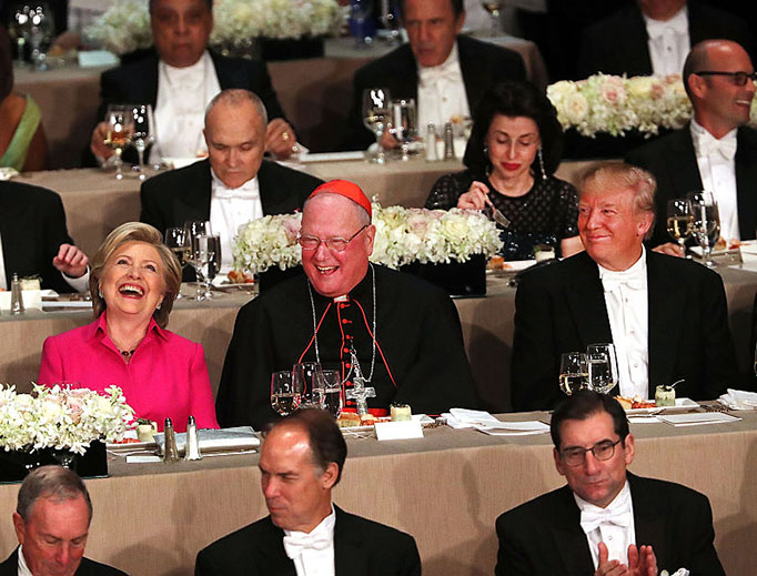 Cardinal Timothy Dolan sits between Hillary Clinton and Donald Trump at the annual Alfred E. Smith Memorial Foundation Dinner at the Waldorf Astoria on October 20, 2016 in New York City.
