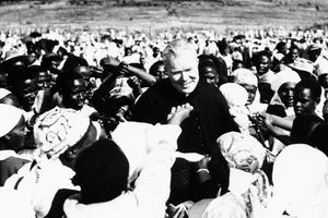 Father Patrick Peyton is surrounded by Kenya natives after a rally in the Kamba Reserve, 40 miles from Nairobi, in the heart of the Mau Mau country. Many asked him to bless their rosaries, crucifixes, medals and babies.