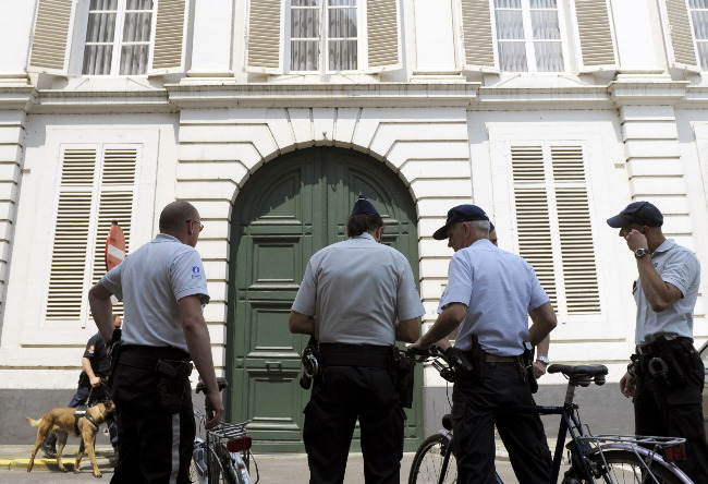 Police officers stand outside the residence of the archbishop of Mechelen-Brussels in Mechelen, Belgium, June 24. Belgian investigators searched Church headquarters in Belgium, the archbishop's residence as well as the home of Cardinal Godfried Danneels as part of an investigation into alleged priestly sexual abuse.