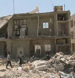 Residents of Azaz, Syria, walk past a bombed-out building in August 2012.
