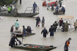 Above, people and rescue boats line a street at the east Sam Houston Tollway as evacuations continue from flooding in Houston Aug. 28. Below, a rescuer moves Paulina Tamirano, 92, from a boat to a truck bed as people evacuate from the Savannah Estates neighborhood as Addicks Reservoir nears capacity Aug. 29 in Houston. Houston Police SWAT officer Daryl Hudeck carries Catherine Pham and her 13-month-old son, Aiden, after rescuing them from their home surrounded by floodwaters Aug. 27 in Houston. An image of Our Lady of Guadalupe sits on Hickory Lane in Crosby, Texas, Sept. 1. Staff Sgt. Lawrence Lind, left, hoists a child into a Black Hawk helicopter while Sgt. Ray Smith, right, helps the boy who was rescued in Port Arthur, Texas, Aug. 30. 