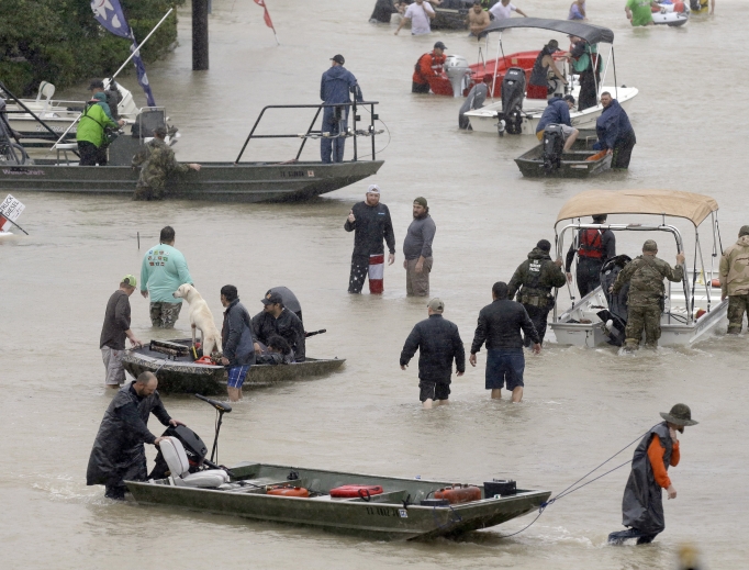 Above, people and rescue boats line a street at the east Sam Houston Tollway as evacuations continue from flooding in Houston Aug. 28. Below, a rescuer moves Paulina Tamirano, 92, from a boat to a truck bed as people evacuate from the Savannah Estates neighborhood as Addicks Reservoir nears capacity Aug. 29 in Houston. Houston Police SWAT officer Daryl Hudeck carries Catherine Pham and her 13-month-old son, Aiden, after rescuing them from their home surrounded by floodwaters Aug. 27 in Houston. An image of Our Lady of Guadalupe sits on Hickory Lane in Crosby, Texas, Sept. 1. Staff Sgt. Lawrence Lind, left, hoists a child into a Black Hawk helicopter while Sgt. Ray Smith, right, helps the boy who was rescued in Port Arthur, Texas, Aug. 30. 