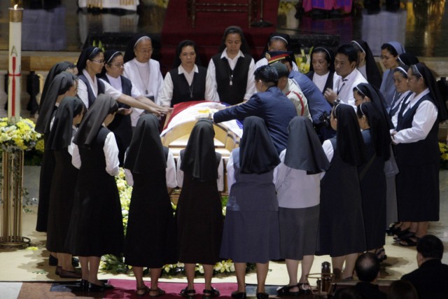 Nuns circle the casket of former Philippine President Corazon Aquino during services at the cathedral in Manila Aug. 3.