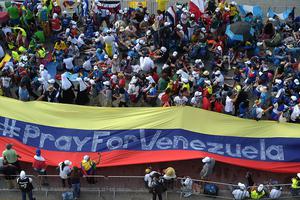 Pilgrims hold a giant flag reading 'Pray for Venezuela' as they wait Jan. 24 for the arrival of Pope Francis for his welcoming ceremony at Campo Santa Maria La Antigua in Panama City during World Youth Day. 