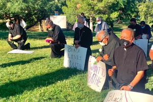 Bishop Mark Seitz prays with other clergy members.