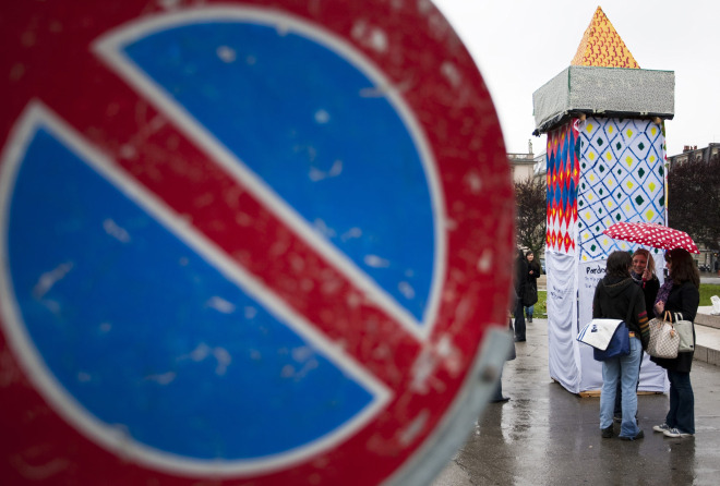 ‘ALARMING MISTAKE.’ People talk in front of a symbolic minaret in Geneva to protest the results of a Nov. 29 vote. The bishops of Switzerland said the country’s ban on the construction of minarets (Muslim prayer towers) represents an obstacle to interreligious harmony.