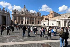 Pilgrims in St. Peter's Square watch the video broadcast of the Angelus March 8. 