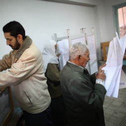 A man votes, and another studies his choices at a polling station in the Shubra district on the second day of voting on Nov. 29 in Cairo, Egypt. Eleven months after the fall of Hosni Mubarak 45 million Egyptians are electing members parliament. The complicated process will take four months to conclude. Presidential elections are expected to be held in 2012.