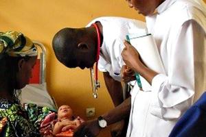 Camillian Father Bernard Kinvi visits a mother and child at John Paul II Hospital in the Central African Republic. 
