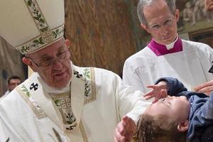Pope Francis baptizes babies on Jan. 10 in the Sistine Chapel.
