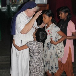 Girls get a good night blessing from Loreto Sister Cyril Mooney at the Rainbow Home in Kolkata, India, Feb. 11. Rainbow Home is a care and schooling program started by Sister Mooney for the orphans and street girls.