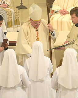 Cardinal Dolan distributes the Constitutions of the Congregation to the newly professed.
