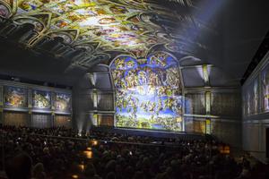 Above, high-definition, 270-degree light projections transport the audience into the Sistine Chapel to learn about each major painting in ‘Universal Judgment: Michelangelo and the Secrets of the Sistine Chapel.’  Below, an actor highlights the election of Pope Clement VII, who commissioned Michelangelo to paint The Last Judgment above the altar, completing the Sistine Chapel we can now see today. 

