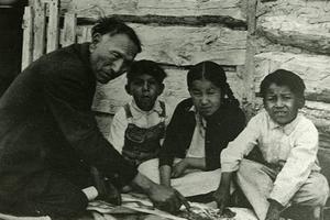 Above, Nicholas Black Elk uses the Two Roads catechism to teach some children about the Catholic faith. Below, Black Elk, holding the rosary, with his daughter Lucy Looks Twice. 
