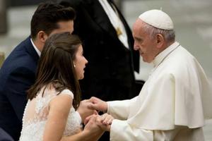 Pope Francis greets a married couple at a Wednesday general audience. 