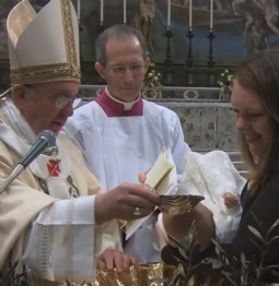 Pope Francis baptizes a baby during Mass Jan. 12 at the Sistine Chapel.