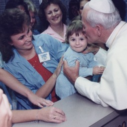 Pope John Paul II kisses Angelina Tsukas-Spiera, 1, at St. Joseph's Hospital in Phoenix in 1987.
