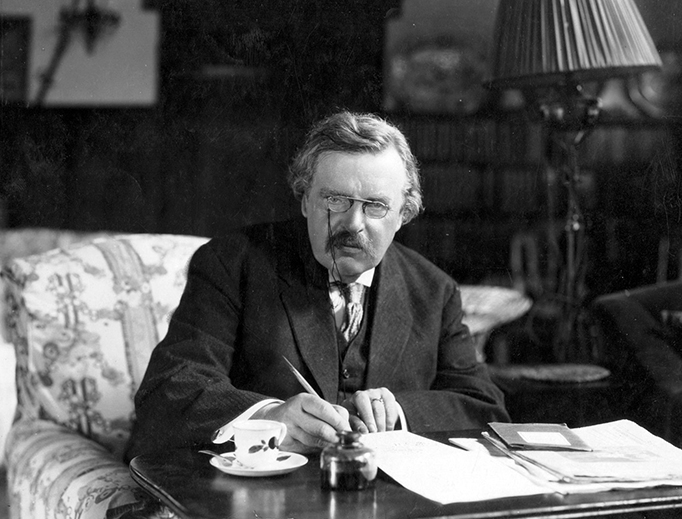 G.K. Chesterton works in his study. 