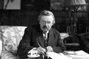 G.K. Chesterton works in his study. 