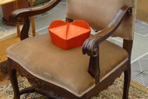 A cardinal’s biretta rests on an empty chair. A cardinal’s biretta rests on an empty chair.