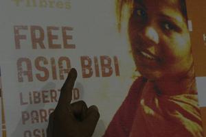In this photograph taken on Sept. 27, 2016, Ashiq Masih, husband of Asia Bibi, points to a poster bearing an image of Asia. 
