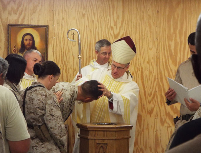 Archbishop Timothy Broglio baptizes military personnel.