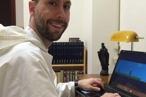 PRIEST-GAMER. Dominican Father Thomas More Garrett, the associate pastor at St. Pius V Church in Providence, R.I., with the Passiontide video game. 


