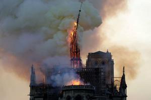 The steeple and spire of the Cathedral of Notre Dame collapses, as the cathedral is engulfed in flames in central Paris on April 15.