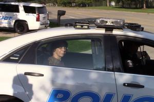 Dr. Monica Migliorino Miller sits in the back of a police car after her arrest