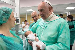 Pope Francis holds a baby in the neonatal unit of San Giovanni Hospital on Sept. 16.