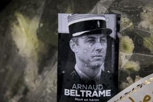A photo of Lt. Col. Arnaud Beltrame placed on a bunch of flowers at the main gate of the police headquarters in Carcassonne, France, March 24. The French policeman, who offered himself up to an Islamic extremist gunman in exchange for a hostage, died of his injuries, raising the death toll in the March 23 attack to four. The officer, a Catholic, was honored Saturday as a national hero of 'exceptional courage and selflessness.'