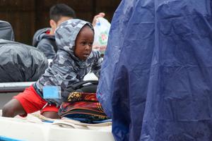 A young boy sits on a boat during rescue operations from flooding due to Hurricane Harvey in Houston. 