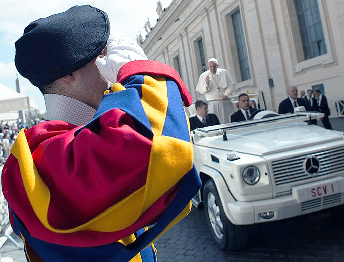 A Swiss Guard salutes Pope Francis as he enters St. Peter's Square in 2015.