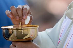 A priest distributes Communion on Divine Mercy Sunday in St. Peter's Square on April 8, 2018.
